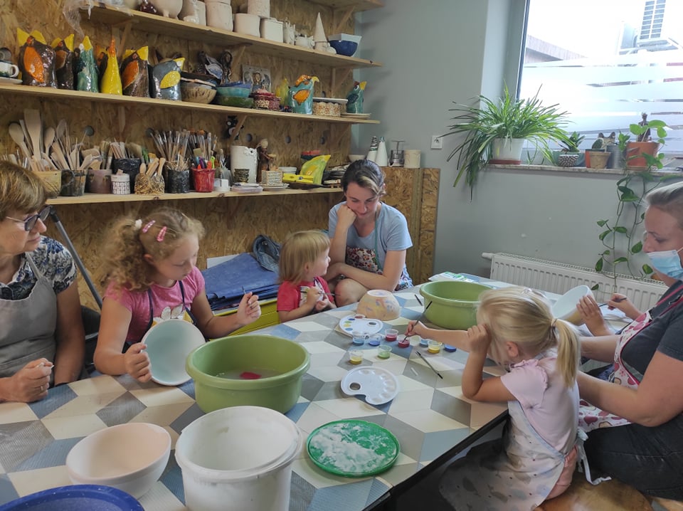 Zdjęcie: dzieci i rodzice podczas zajęć w pracowni ceramicznej