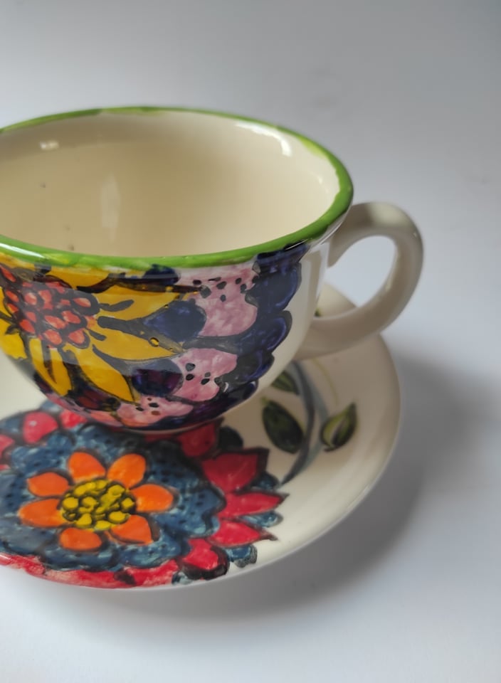 Zdjęcie: ceramiczna filiżanka w kwiaty ustawiona na spodeczku