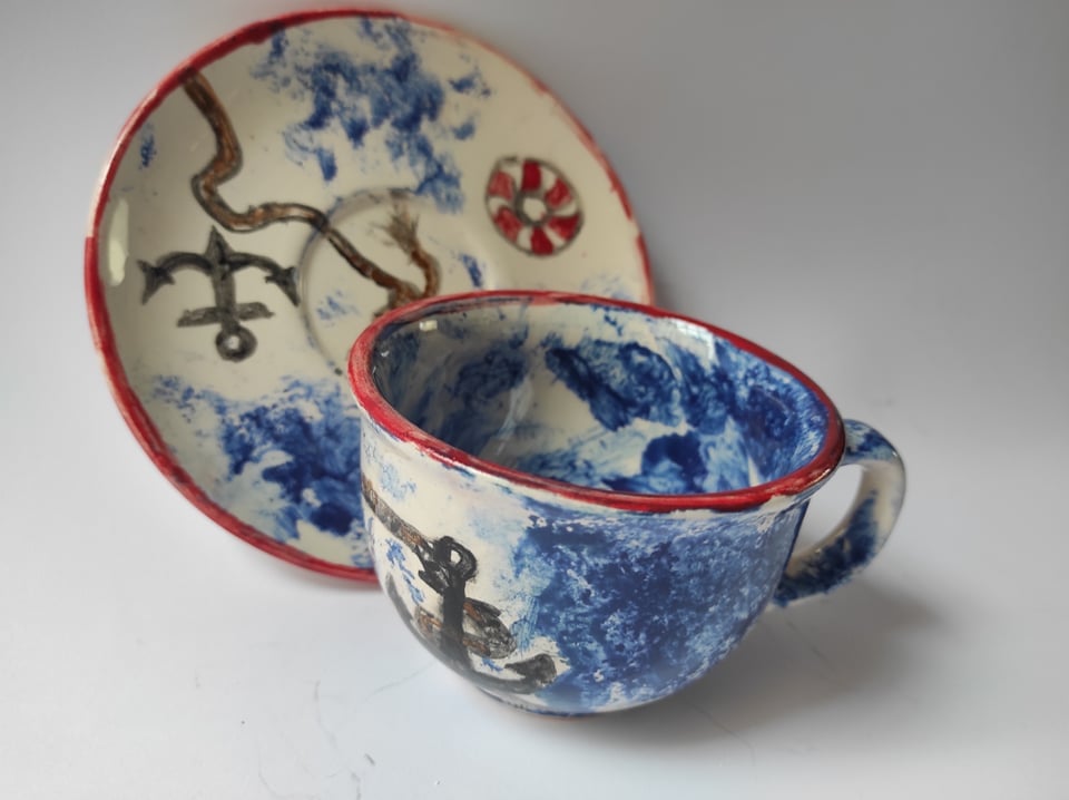 Zdjęcie: ceramiczna filiżanka i talerzyk w marynarskie wzory (kotwica, lina)