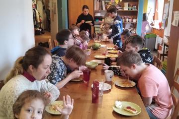Dzieci z różnych krajów jedzą razem posiłek. 