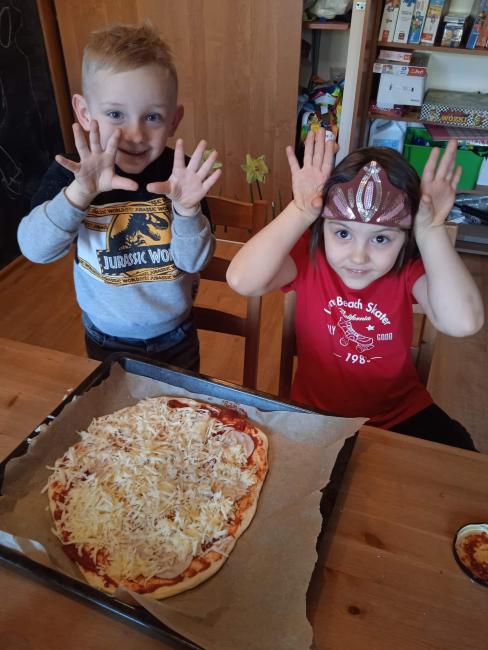 Dzieci z pizzą, którą sami przygotowali. 